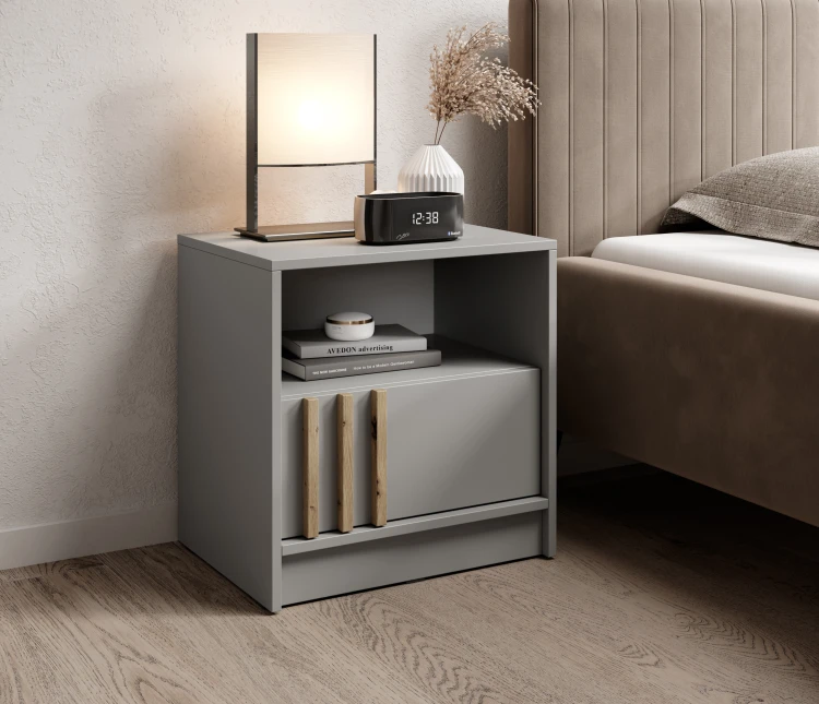 Szafka nocna Nelly S54 szara ustawiona obok łóżka w nowoczesnej sypialni w stylu loft.