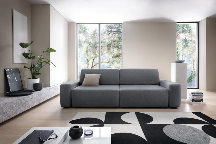 Grafitowa sofa Bouli Raven 18 w nowoczesnym salonie jako centralny punkt wypoczynkowy.