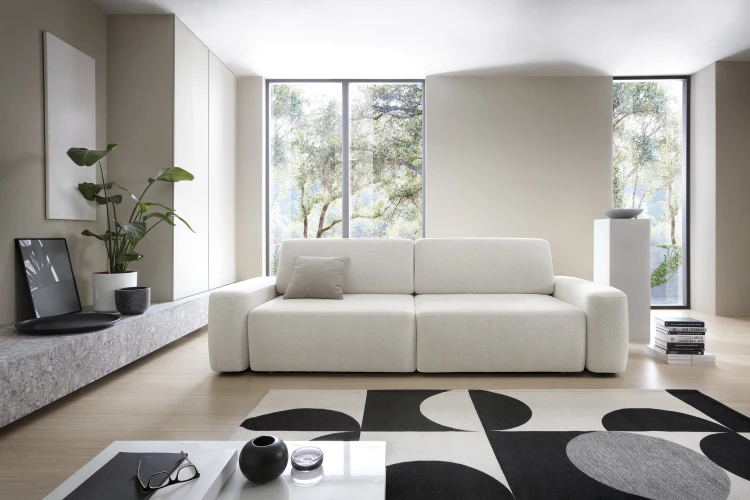 Kremowa sofa Bouli Raven 22 w nowoczesnym, minimalistycznym salonie jako centralny punkt wypoczynku.