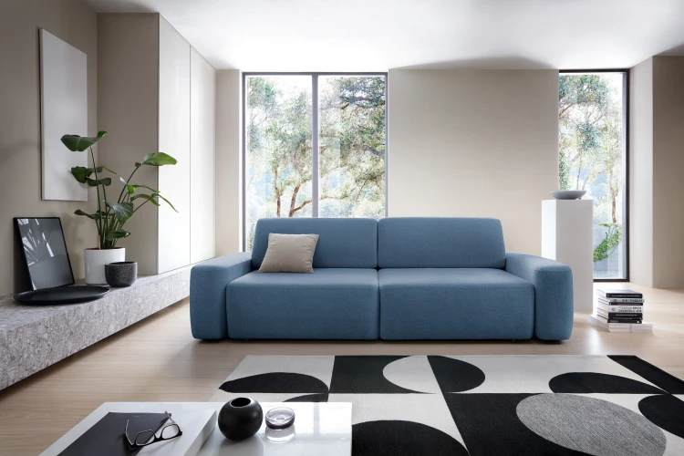 Granatowa sofa Bouli Raven 86 w nowoczesnym salonie jako centralny punkt wypoczynkowy.