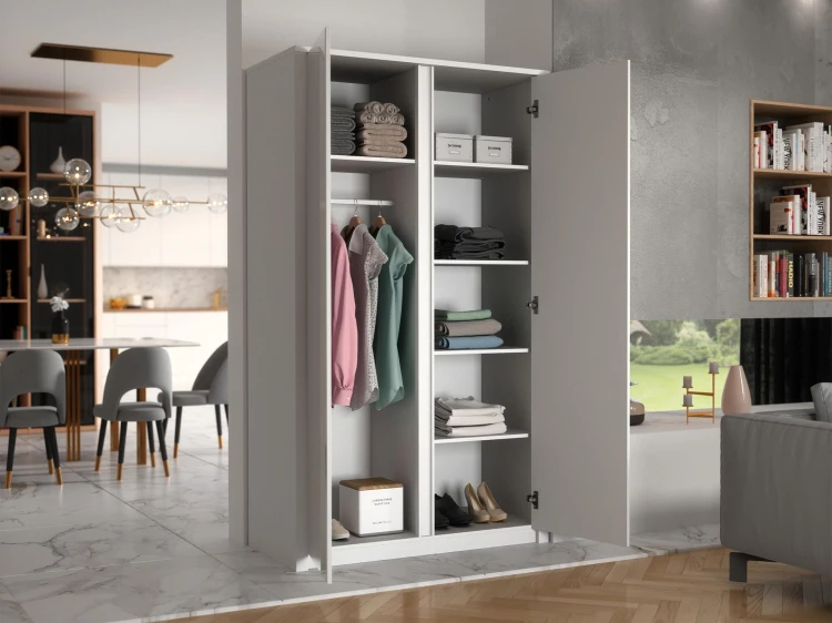 Jasny i przytulny salon w stylu skandynawskim z otwartą szafą dwudrzwiową Maxim Biała, eksponującą poukładaną wewnątrz garderobę i pudełka dekoracyjne.