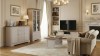 Elegancki salon w stylu modern classic z szeroką szafką RTV Kora Plus KRT2 stanowiącą stabilną podstawę pod duży telewizor, z dekoracjami ułożonymi na blacie.